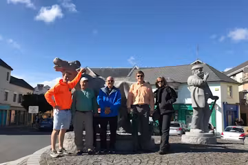 tourists standing in front of statues in ennis
