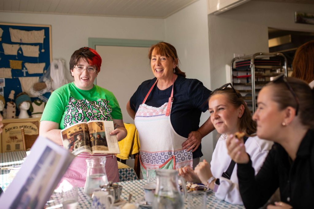 AKphoto (19) Group enjoying a knitting workshop, with a book of Aran stitches, in a cosy room.