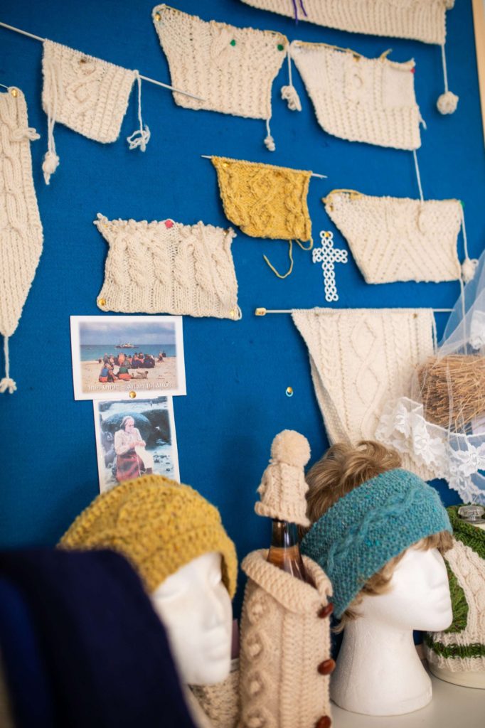 AKphoto (23) Knitted swatches and hats on display board with photos, highlighting traditional patterns and textures.