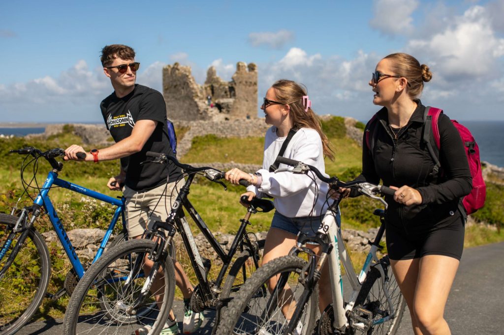 AKphoto (35) Cyclists explore scenic ruins by the sea on a sunny day, perfect for an outdoor adventure in Ireland.