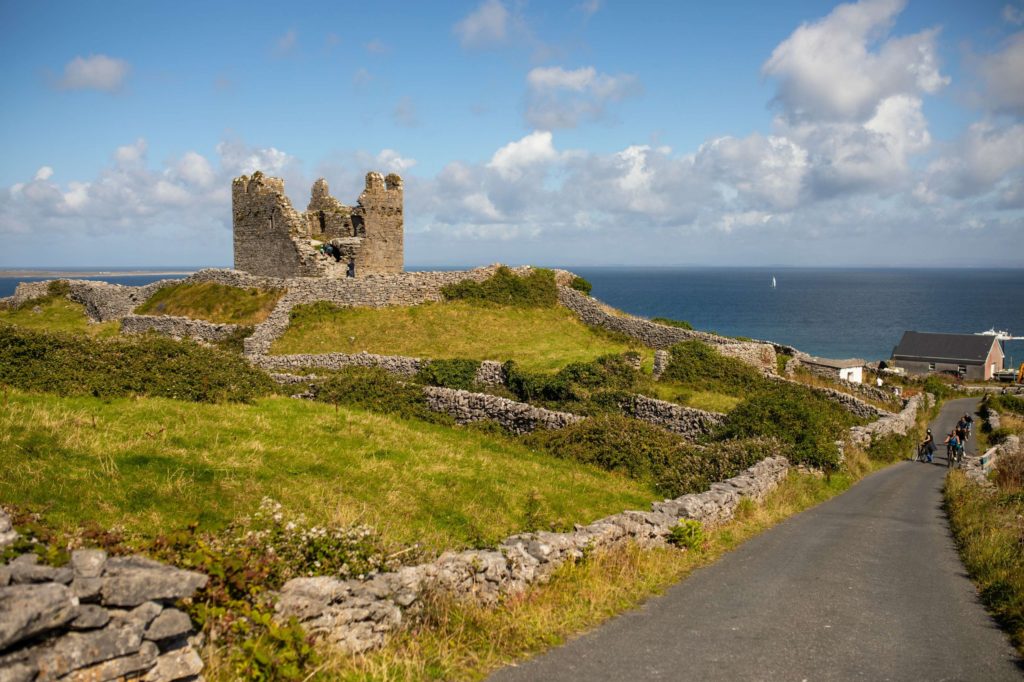 AKphoto (37) Scenic view of Dun Aengus fort on Inishmore, Aran Islands, surrounded by stone walls and ocean under a blue sky.