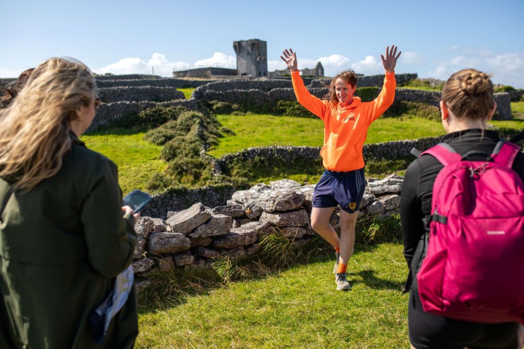 AKphoto (47) Ollie energetically explaining historic site to visitors in vibrant countryside setting.